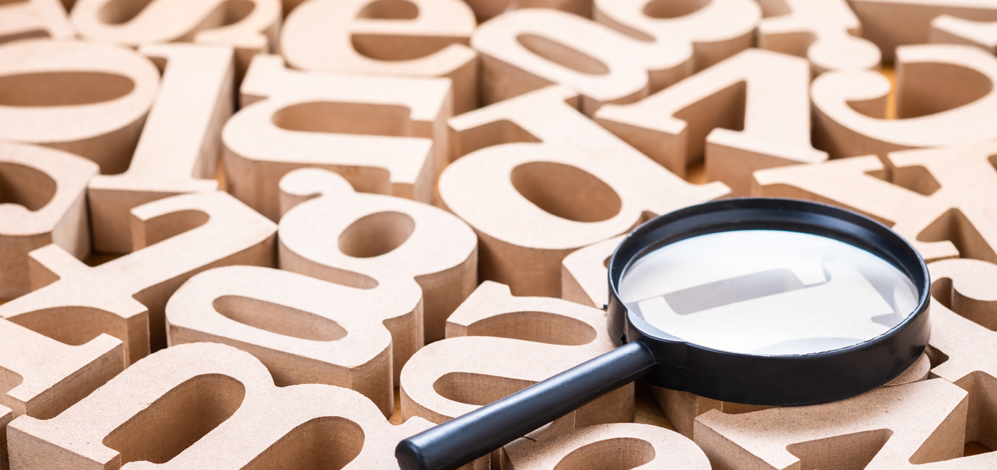 Magnifying glass on Wood Alphabets - marketing acronyms