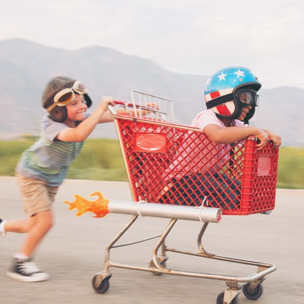 Two boys racing in a shopping trolley